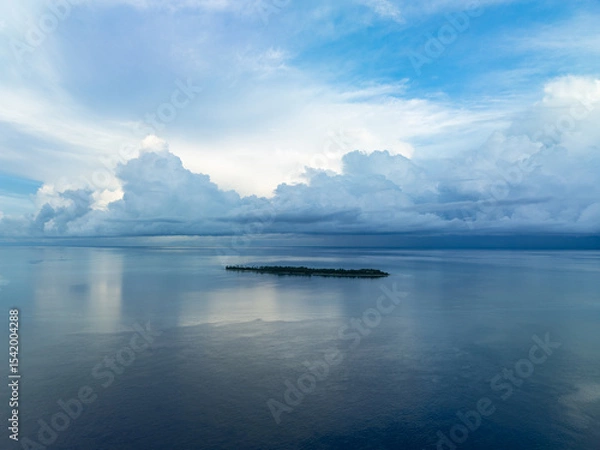 Obraz A serene sunrise silhouettes an island within Wakatobi National Park, off the coast of Sulawesi. This area is a popular destination for divers and snorkelers due to its high marine biodiversity.