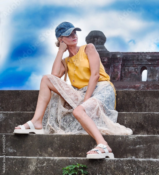 Fototapeta A woman sits on ancient ruins in Nha Trang, Vietnam - a moment of silence amidst the historical heritage and nature of Southeast Asia. Tourism concept