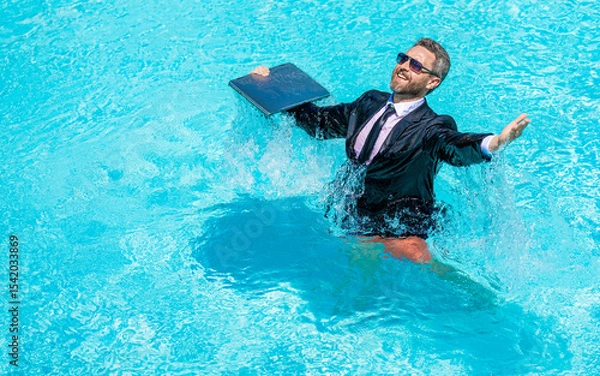 Obraz Business retreat. Happy businessman on summer vacation. Freelancer has remote work online. Businessman in suit with laptop at swimming pool. Successful freelancer. Business trip success, copy space