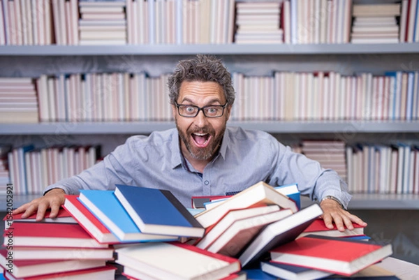Obraz genius studying homework literature near pile of books. man teacher read book. school education in college. knowledge day. overwork of bookworm. teacher genius in school library. study with book