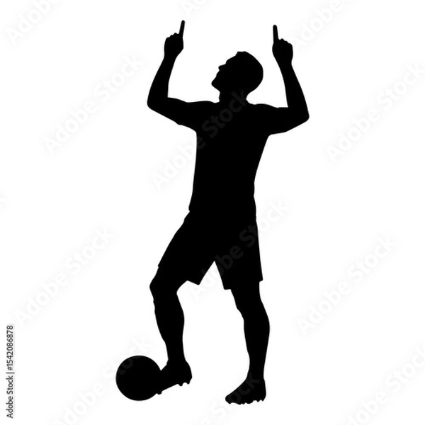 Fototapeta a silhouette of a soccer player celebrating a goal with a ball and pointing fingers up in the air
