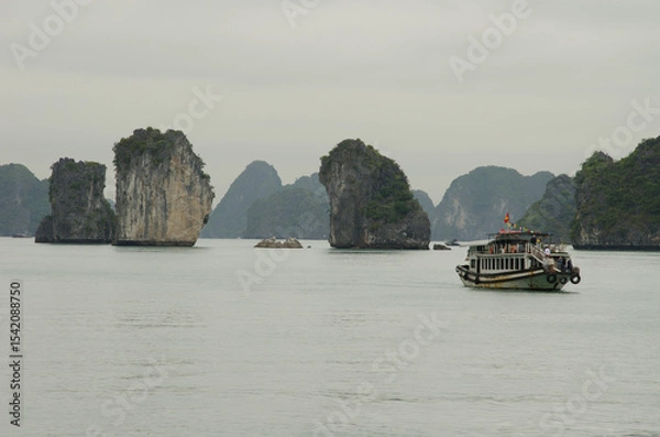 Obraz February 25, 2024, Lan Ha Bay: Tourist boat and limestone cliffs. Cat Ba Archipelago. Vietnam.