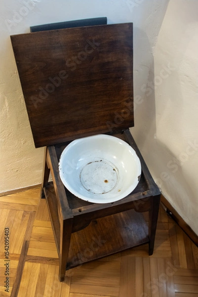 Obraz An old washbowl installed in a historical table with an open lid