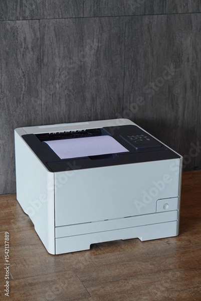 Fototapeta closeup white and black plastic printer and white paper on wood floor, grey tile wall background, technology, object, office, decor, business, copy space