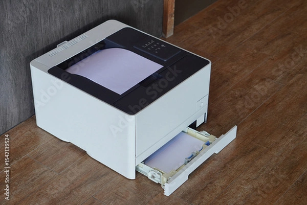 Fototapeta top view, side black and white laser printer sitting on a wooden floor and grey and black wall, technology, object, decor, copy space