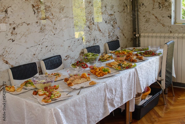 Fototapeta Food, salads, meat, barbecue, etc. are served on the tables, ready to eat.