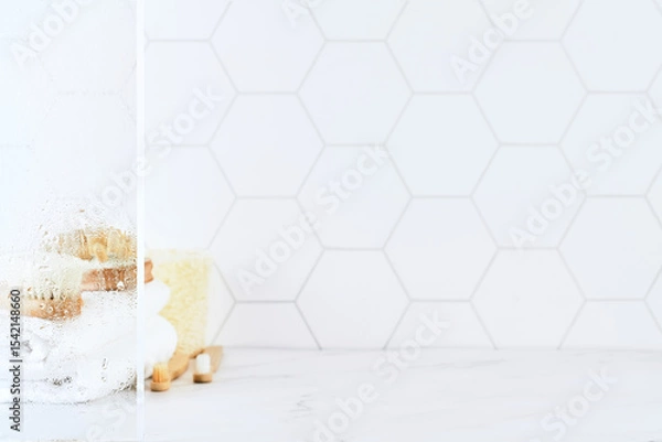 Obraz Marble table in bathroom with glass shower door with water droplets, towels, toothbrushes, sponges and body care comb in white. Minimal abstract background for product presentation. Design element.