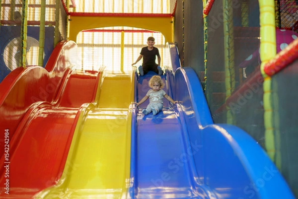 Obraz Children enjoying colorful slides in an indoor play area during the afternoon