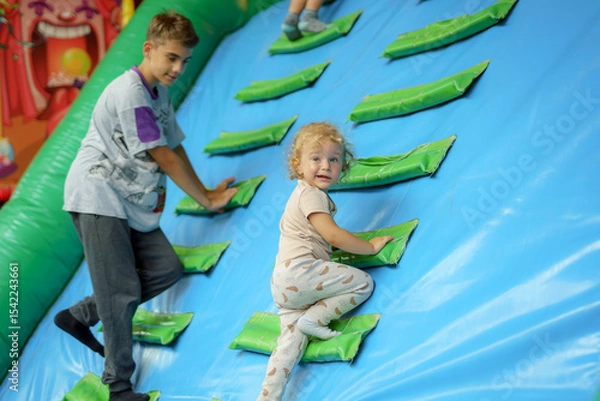 Obraz Kids enjoy indoor climbing activity at a vibrant play center during a fun afternoon