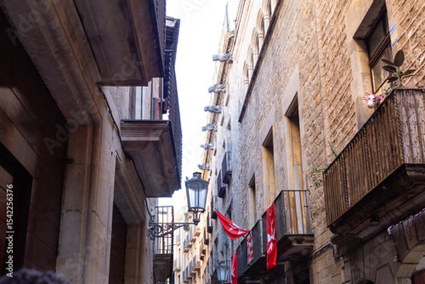 Obraz Narrow street with catalan flags flying in barcelona's gothic quarter