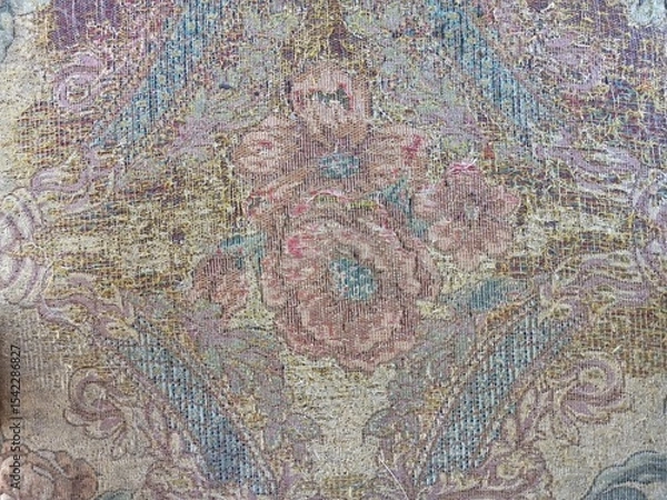 Fototapeta Intricate Floral Pattern on Worn Fabric Tapestry