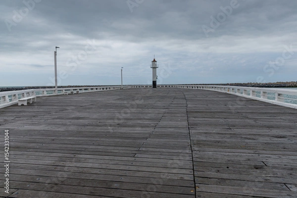 Fototapeta Wooden pier with a lighthouse at its end