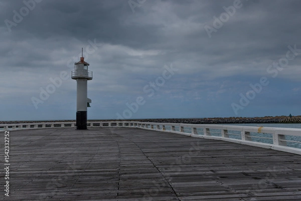 Fototapeta Wooden pier with a lighthouse at its end