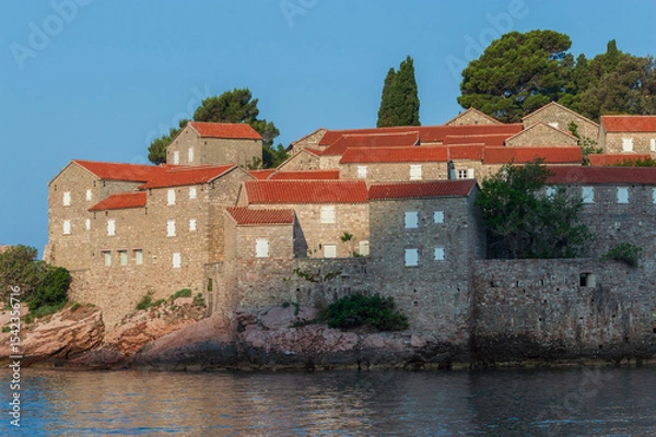 Fototapeta Sveti Stefan Island Hotel, stone houses of a medieval fortress village with tiled roofs on the Adriatic coast of Montenegro