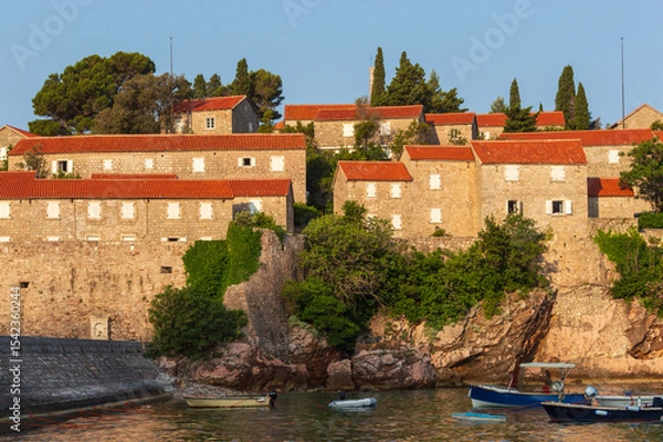 Fototapeta Sveti Stefan Island Hotel, stone houses of a medieval fortress village with tiled roofs on the Adriatic coast of Montenegro