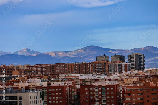 Obraz Brown houses in spanish town with mountains on horizon under blue sky	
