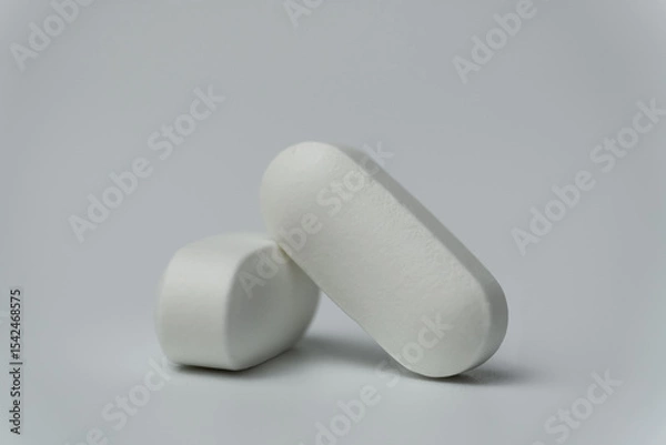 Fototapeta Close up macro shot of a two tablets pills on a light grey background