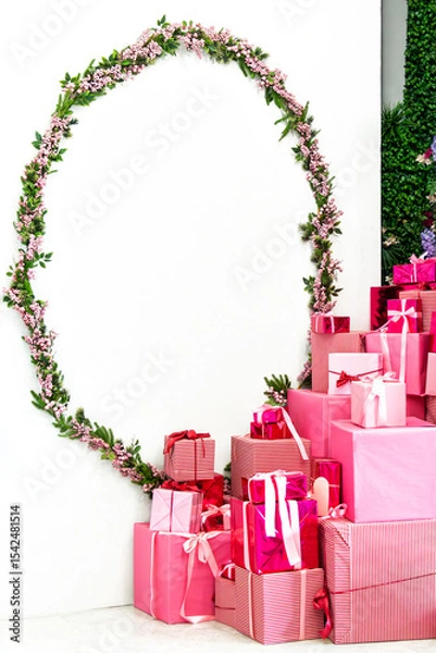 Fototapeta Decorative pink gifts surrounded by floral arrangement in a festive corner