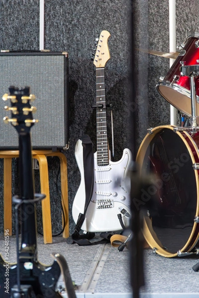 Fototapeta Band setup with electric guitar and drums on stage during music rehearsal in daylight hours