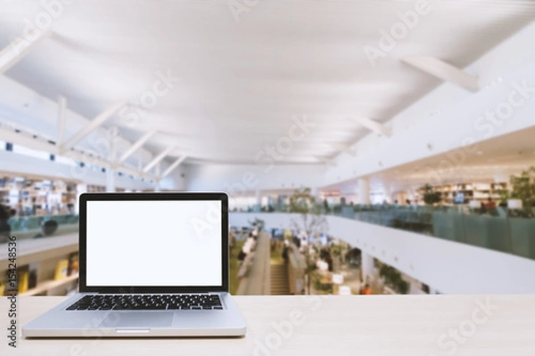 Fototapeta Laptop with blank screen on table with work space area blurred background for concept technology 4.0; work every place; co worker.