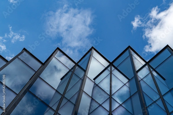 Obraz Modern glass building with sky and clouds reflection, abstract urban architecture detail