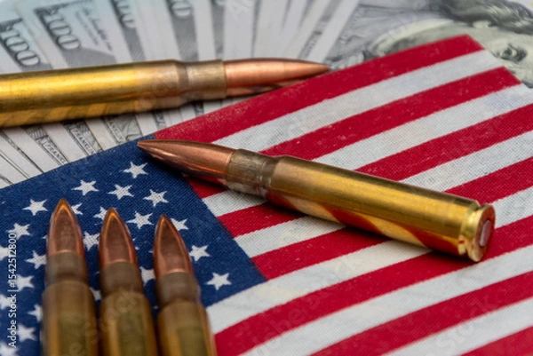 Obraz Live ammunition rests on the American flag, with $100 notes.