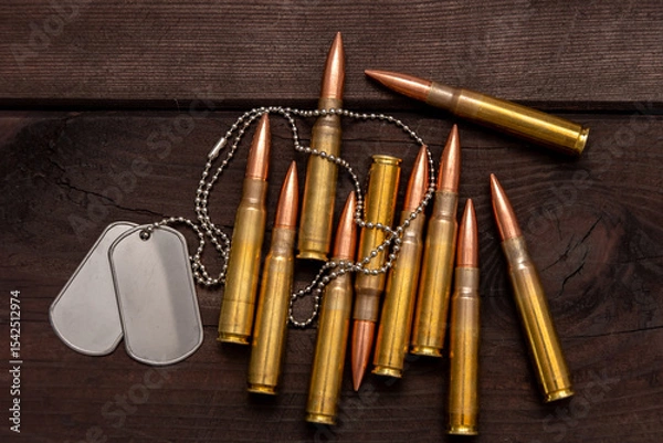 Obraz Close-up of army badges and live ammunition against a dark background, symbolising the concept of mercenary and military service.