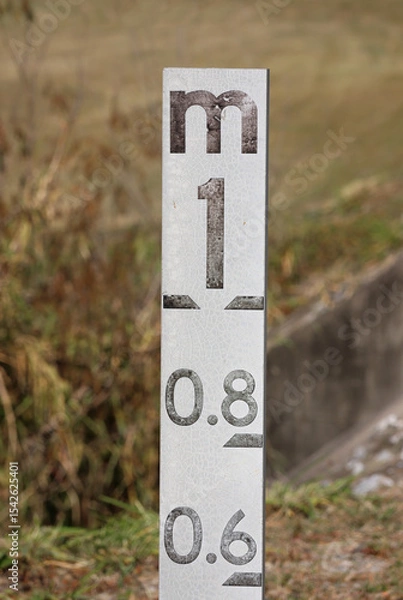 Fototapeta Close-up of a flood level marker indicator in a grassy environment in Australia