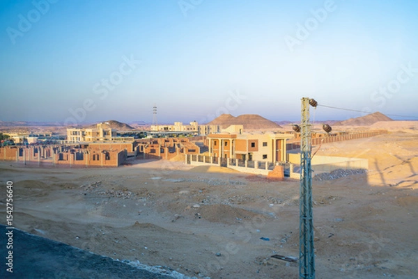 Obraz A picturesque view of Aswan's desert landscape featuring modern construction projects, captured at dawn during a bus journey to Abu Simbel Temples.