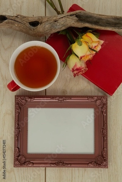 Obraz Photo frame, lemon tea, diary and flowers on wooden table