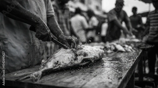 Obraz Hands at Work: Fish Cutting Scene in Crowded Market Street – Monochrome Action Shot