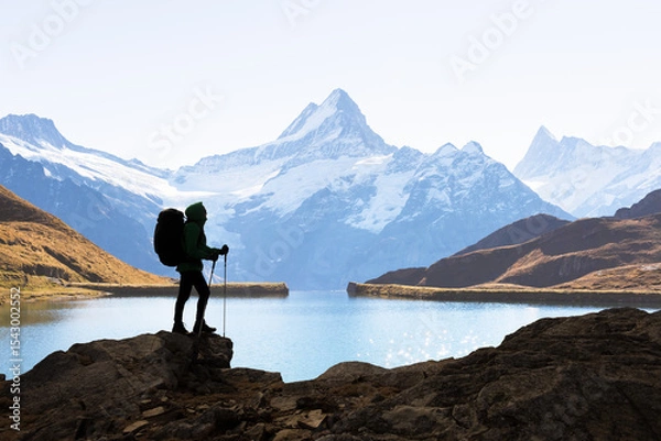 Obraz Silhouette of a backpacker against the Bachalpsee lake and snowy Swiss Alps mountains. Travel and adventure concept