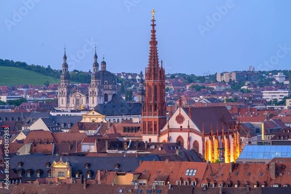 Fototapeta Wurzburg's Marian Chapel illuminated at dusk with city rooftops in the foreground - Germany