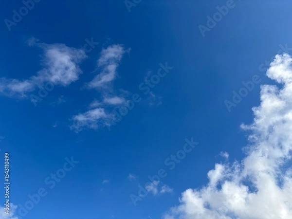 Fototapeta Beautiful blue sky with white clouds. The sky was clear and bright, and clouds were scattered all over the sky. The scene was peaceful and serene, as if the viewer was gazing at a beautiful day