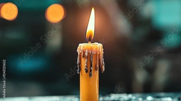 Fototapeta A single orange candle with a flickering flame and dripping wax sits on a dark surface.