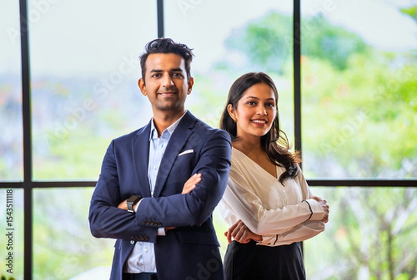 Fototapeta Posing with success and smiling confidently, Indian business professionals stand in office together