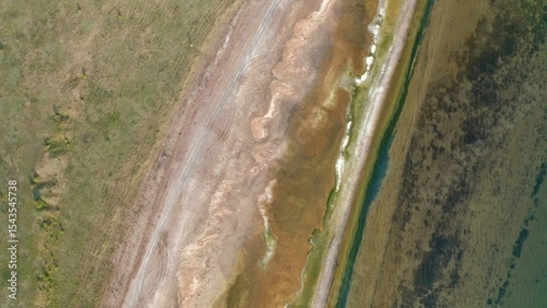 Fototapeta An aerial view of the green waters and salty coastline of an estuary.