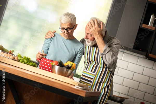 Obraz Verry disappointed senior couple looking in pot of failed meal.