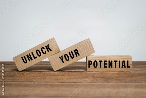 Fototapeta unlock your potential words symbol on wooden blocks isolated on white background. minimalist concept. motivational words