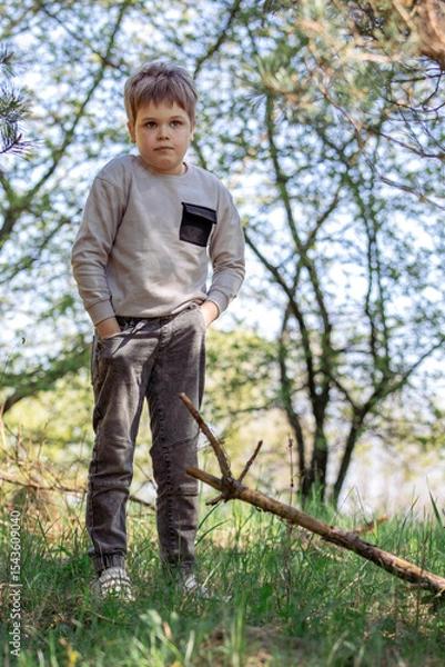 Obraz A cute little boy searching for something in his pants pockets