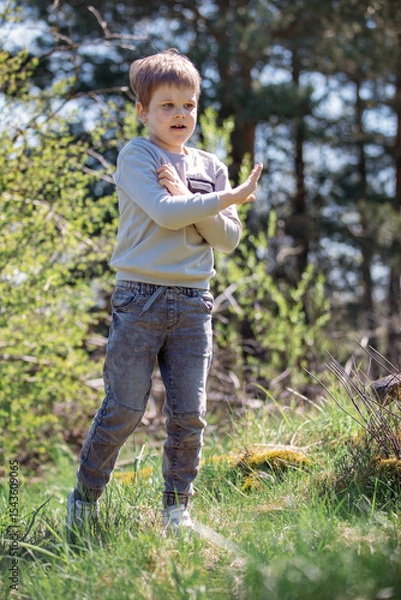 Obraz A cheerful, playful boy against a bright summer forest background