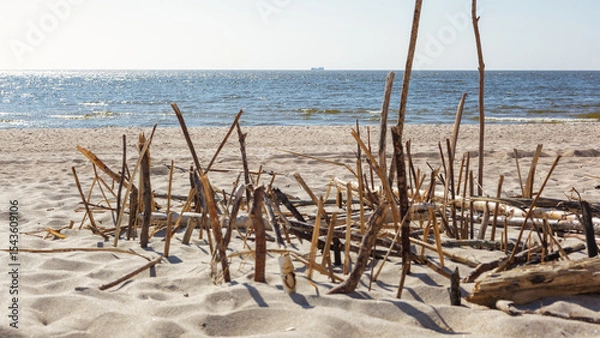 Obraz Summer beach landscape, in the foreground a composition of straws and wooden sticks on the sand