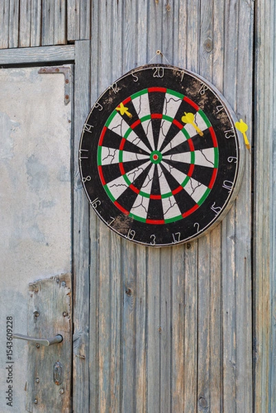 Obraz A dart board is hung outdoors on an old wooden wall