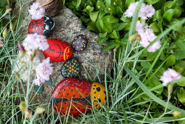 Obraz Handmade painted pebbles resemble ladybugs in a simple village flower garden