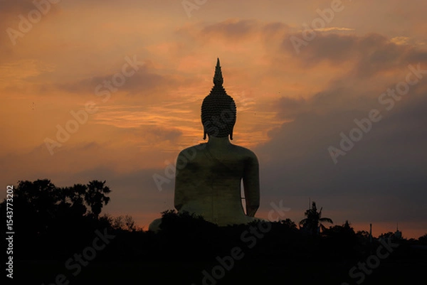 Obraz The largest golden Buddha statue with green rice field foreground at Wat Muang Temple in Ang Thong Province, Thailand.