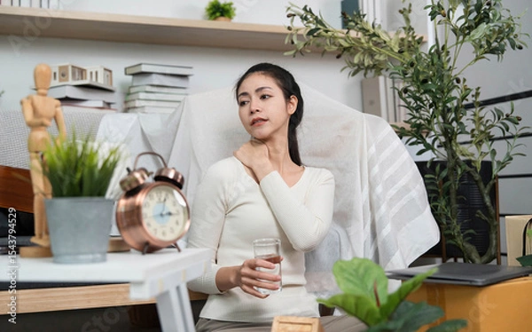 Obraz Self-care during moving. Woman relaxing with water and stretching her neck in a home setting.