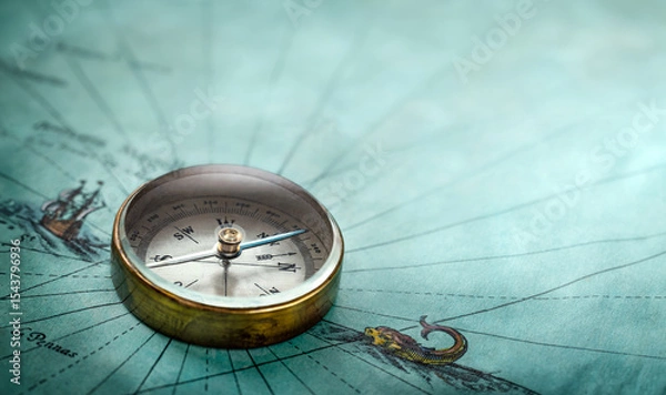 Obraz Magnetic old compass on old map. Travel, geography, history, navigation, tourism and exploration concept background. Retro compass on geography map.