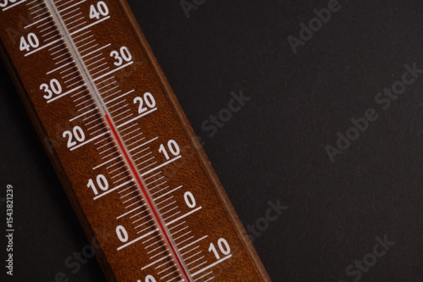 Fototapeta Thermometer shows temperature readings prominently against a dark background, showcasing clear scale details and vibrant markings