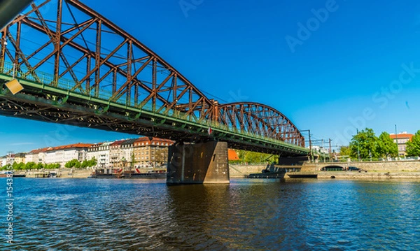 Fototapeta A view from the Vltava river passing under the Vysehrad Railway Bridge in Prague in springtime
