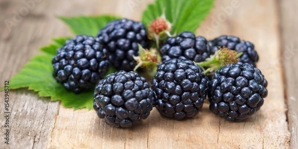 Obraz A collection of juicy, ripe blackberries sit on a weathered wooden background, ready to be enjoyed.